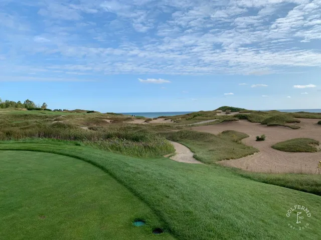 A green on the Straits Course set above the lake, the flagstick against the water.