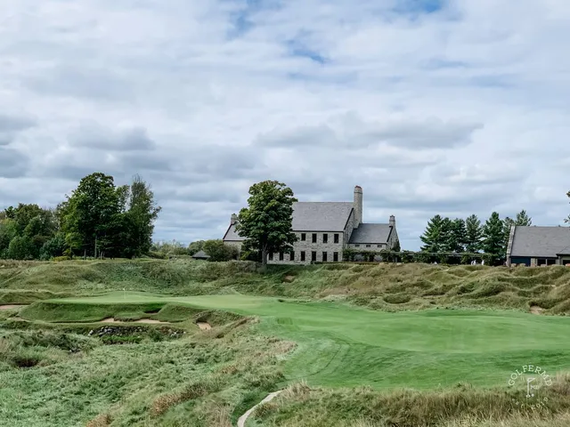 A green on the Straits Course guarded by sand, with the shoreline behind the hole.