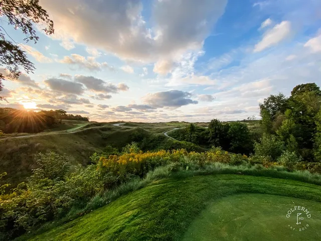 A green and flagstick on the Straits Course, a deep bunker short of the hole and the dunes behind.