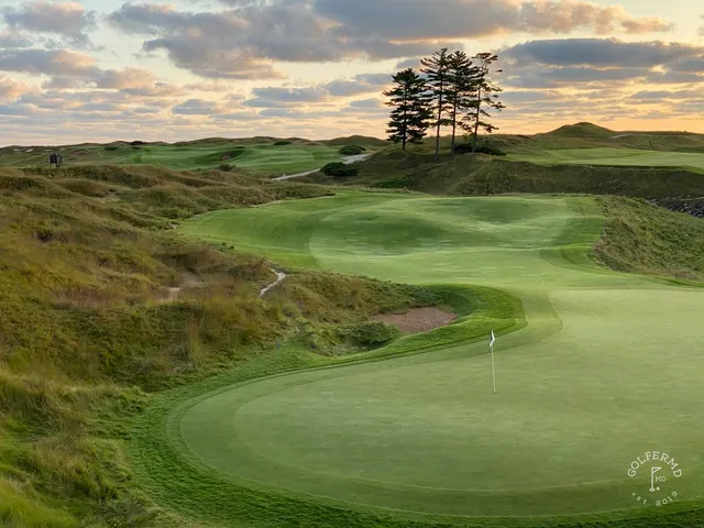 A wide hole on the Straits Course, the fairway set between sand hills and the lake.