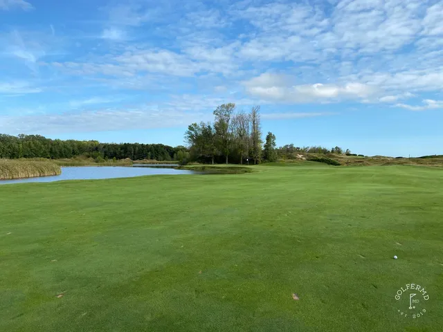A view back up a hole on the Straits Course, the tee in the dunes and the lake to the side.