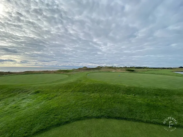 A green on the Straits Course seen from behind the hole, the fairway running back through the dunes.