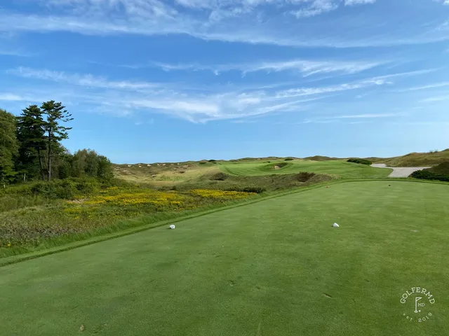 Sand in the foreground on the Straits Course, with the flagstick beyond the bunker.