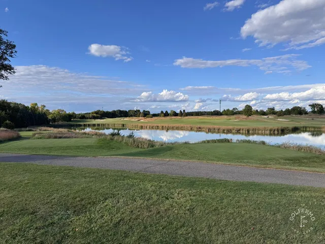 A golfer hitting a shot at Windsong Farm, with the fairway and fescue ahead.