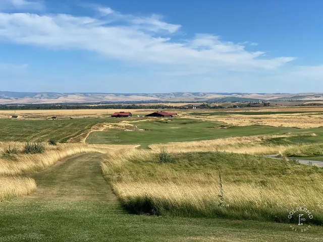 A wide green complex at Wine Valley, with the flagstick, a bunker in front, and the fairway stretching toward the hills.
