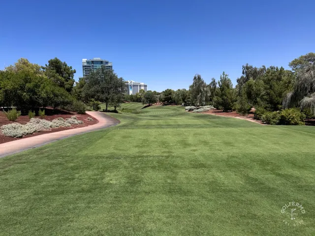 A close view of a flagstick at Wynn Golf Club, with the mountains behind the green.